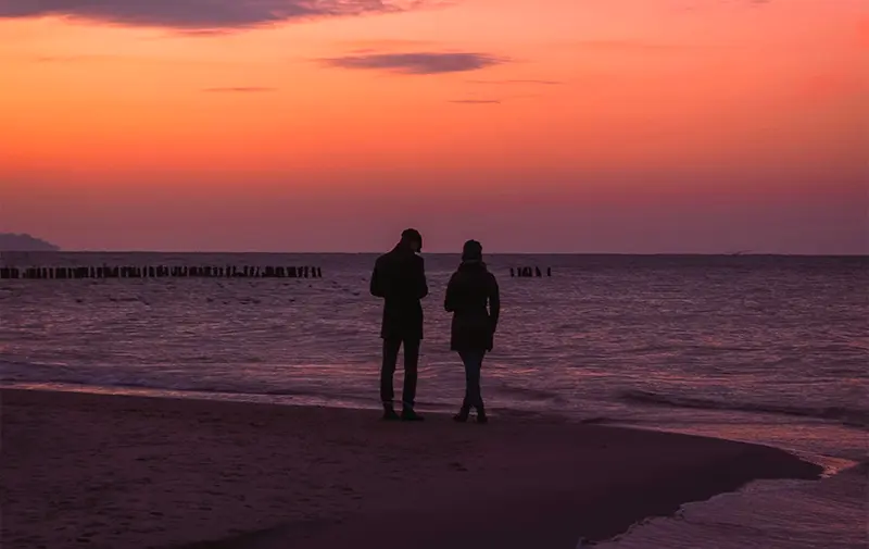 Coppia sul molo al tramonto